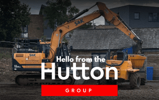 Image features diggger and dumper truck on the land where the Newhall Community Centre will be built. It also features the Hutton Group logo.